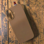 digitaley.co brown silicone iPhone case with a 3D slim-waist tea glass motif on a wooden background.