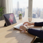 digitaley.co white wireless keyboard and mouse set on a wooden desk with a tablet and coffee mug.